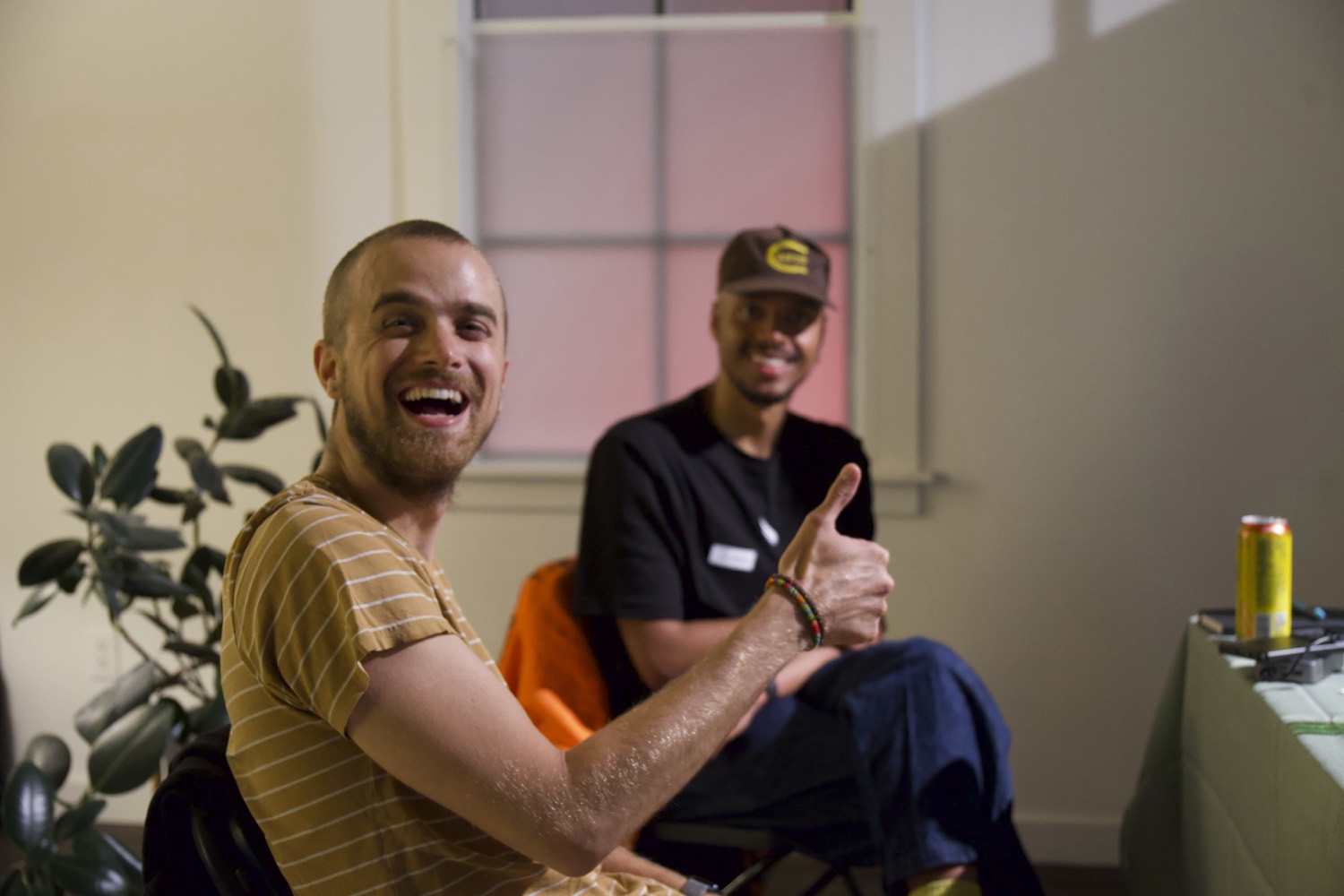 Two people mid-laugh in the lounge between sessions