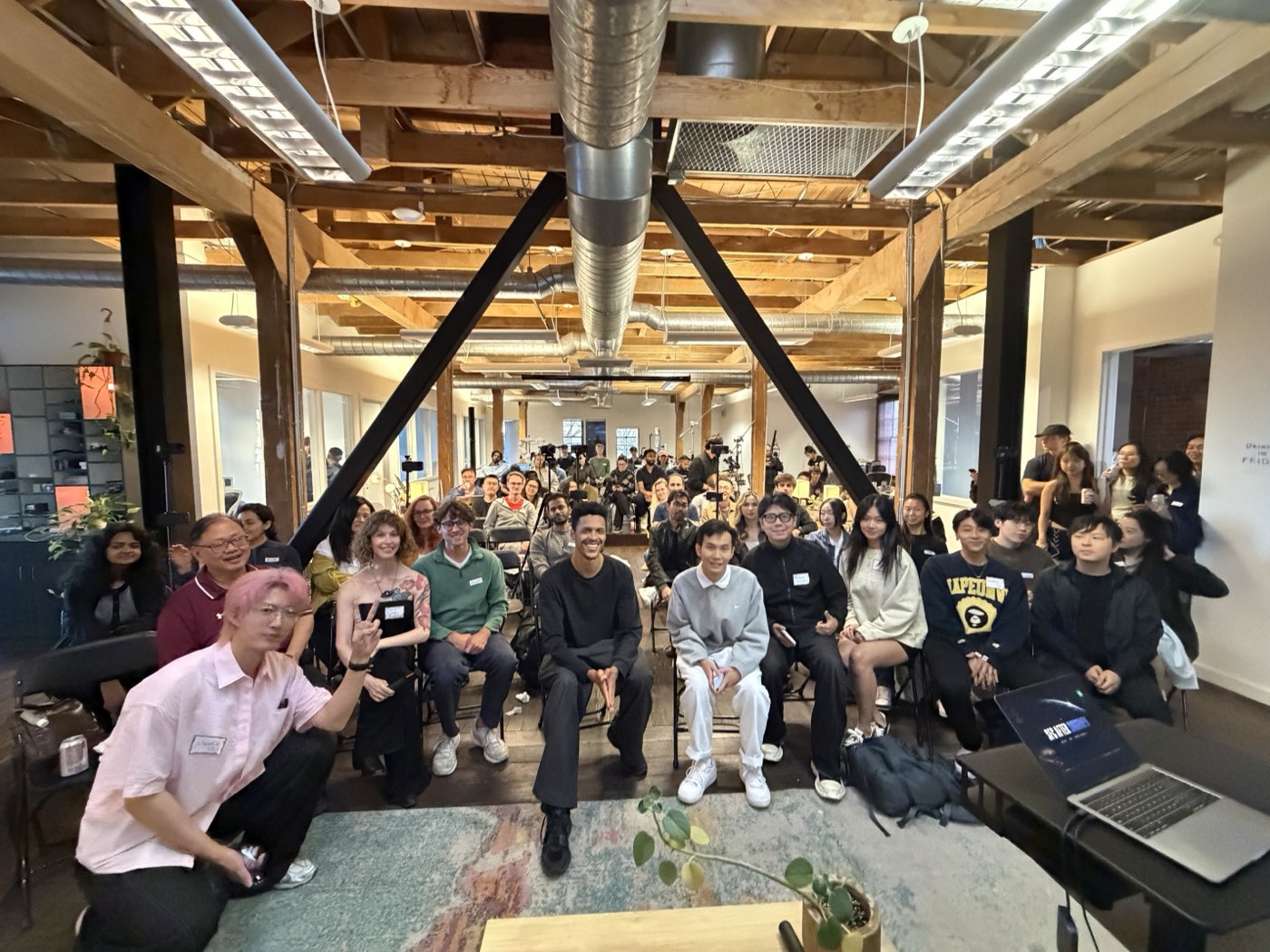 The factory floor packed out for an evening talk, timber beams overhead